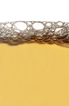 Vertical close up of beer froth isolated on white background
