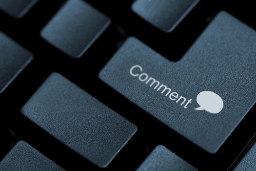 Close up of black buttons on a keyboard with the word comment and a speech bubble written on one of them