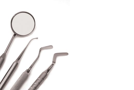 Horizontal set of chrome dental tools, viewed from the top isolated on white background