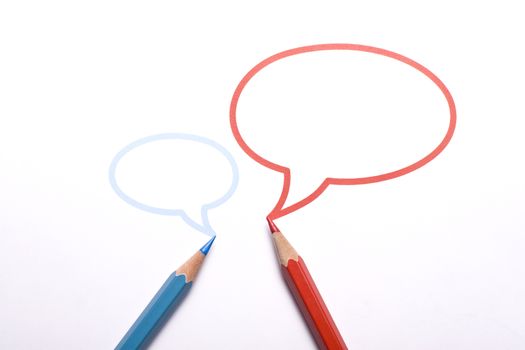 Horizontal top view of a red and a blue pencil with speech bubbles of different sizes above them isolated on white background. 