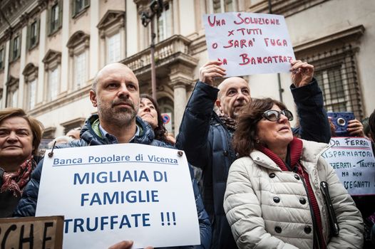 ITALY, Rome: As Italy's economy struggles in the face of a banking crisis, protesters fill the Piazza Santi Apostoli in Rome on January 31, 2016. They voice their fears about the state of their savings.Man's sign at left reads: Banca Popolare di Vicenza swindled thousands of families.