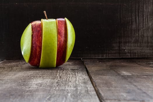 The image shows apple surrounded by a measuring tape referring to diet and health concept on wooden background