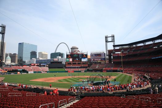 Fans gather for a late season Cardinals game at Busch Stadium, under the city skyline.