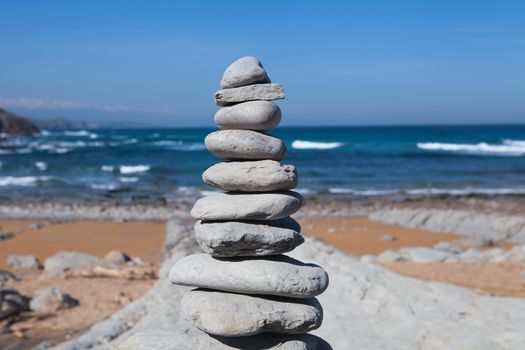 An scene where several stones are in balance, the scene is a relax, quiet and spa picture with the sea and a blue sky
