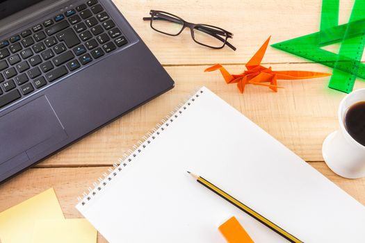 Collection of objects of an freelance worker or someone who works at home, on wooden background illuminated with natural light and photographed from above