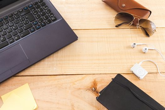 Collection of objects of an freelance worker or someone who works at home, on wooden background illuminated with natural light and photographed from above