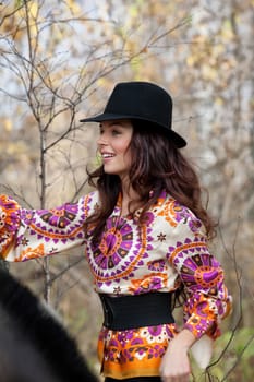 Young beautiful woman in fashionable clothing in the forest