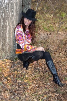 Young beautiful woman in fashionable clothing in the forest