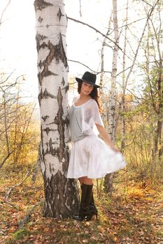 Young beautiful woman in fashionable clothing in the forest