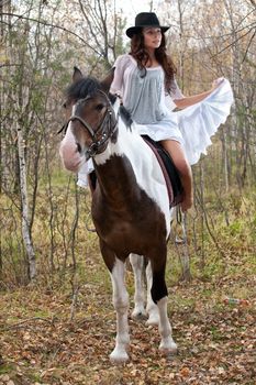 Young woman and horse in a forest