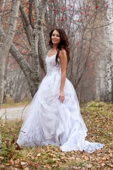 Young woman wearing a wedding dress in a forest