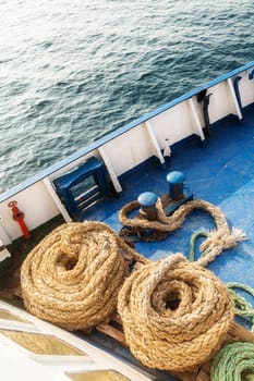 Two old fleecy ropes curtailed into a spiral on the deck of the vessel