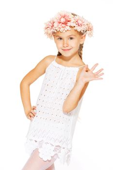 Little girl posing for the camera in white dress with wreath
