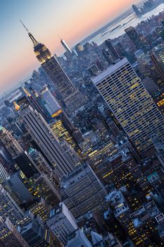 New York City. Manhattan downtown skyline with illuminated Empire State Building and skyscrapers at dusk.