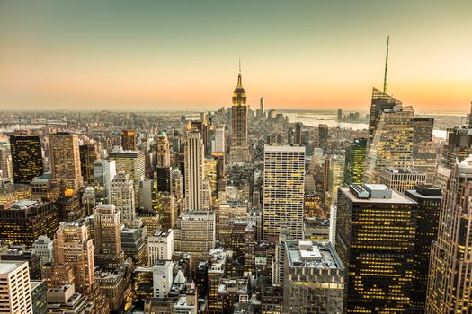 New York City. Manhattan downtown skyline with illuminated Empire State Building and skyscrapers at dusk.