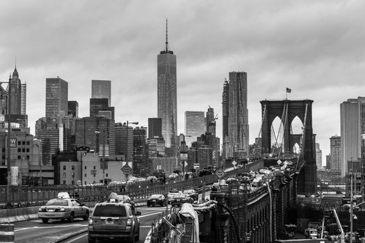 New York City, United States of America - March 25: Traffic on Brooklyn bridge and New York City Manhattan downtown skyline at dusk with skyscrapers over East River panorama on March 25, 2015.