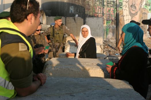 WEST BANK, Qalandia: Palestinians (R) face Israeli soldiers at Qalandia checkpoint on the first friday of the Holy month of Ramadan on July 20, 2012.