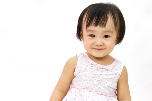 Chinese Little Girl smiles for a portrait in studio on plain white isolated background.