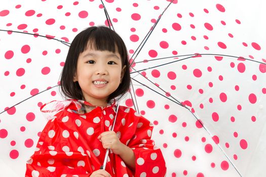 Chinese Little Girl Holding umbrella with raincoat in plain white isolated background.