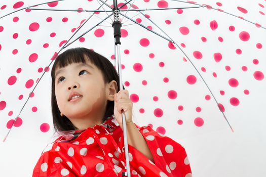 Chinese Little Girl Holding umbrella with raincoat in plain white isolated background.