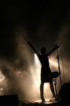Silhouette of an attractive female drummer on stage