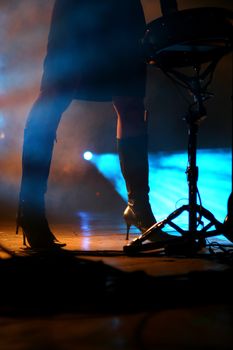 Silhouette of an attractive female drummer on stage