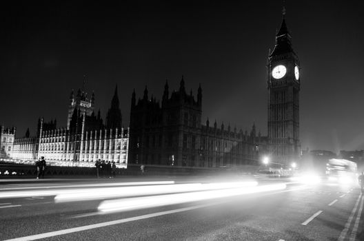 Traffic in front of Big Ben. Pedestrians walking on the pavements.