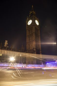 Night view on Big Ben and light trail of a bus in front.