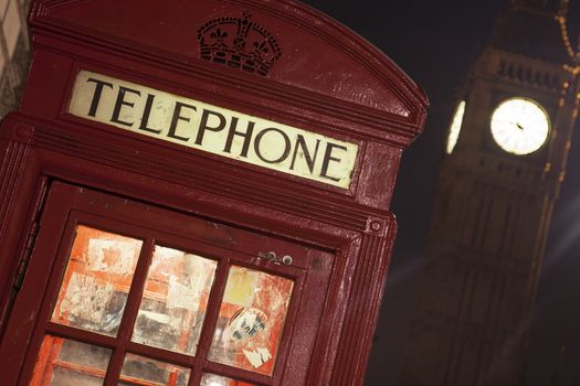 London telephone box and Big Ben in background at night. With light trails.