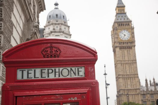 House of Parliament in London with a telephone cell in front view.