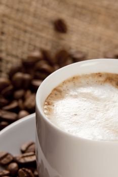 Cup of coffee on a sack with beans for background