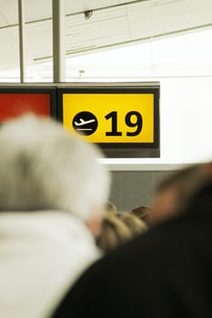 Airport gate number 19 and lots of people waiting