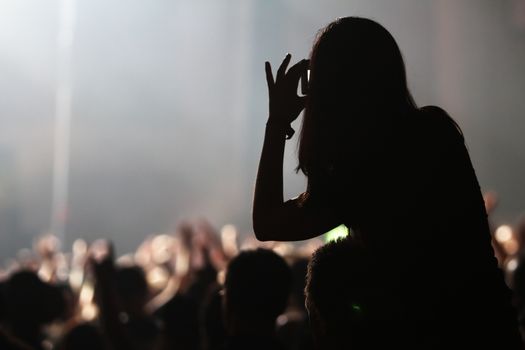 A girl taking picture at a concert