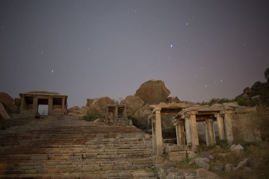 Ruins at night, opposite to Virupaksha - Vijayanagar Temple - at Hampi temple complex in India, real stars with sky movement