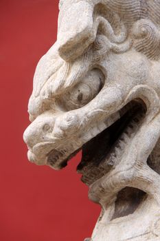 Lion on red background taken infront of an entrance on a garden of the Forbidden City in Beijing, China