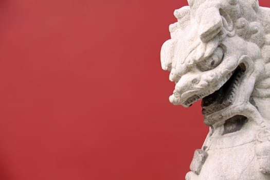 Lion on red background taken infront of an entrance on a garden of the Forbidden City in Beijing, China