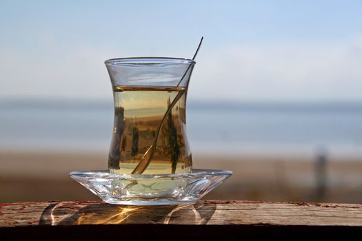 A glass of turkish tea by the sea