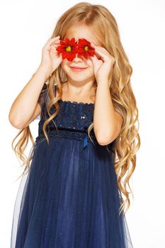 Little cute girl holding two red flowers near her eyes