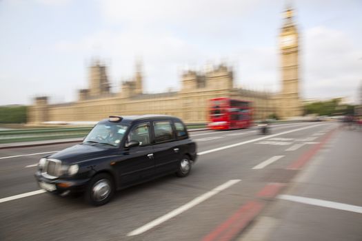 Typical London taxi in front of a Big Ben. Other traffic in the background.