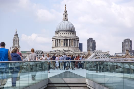 View on St Paul's Cathedral in London from Millennium bridge crowded with tourists.