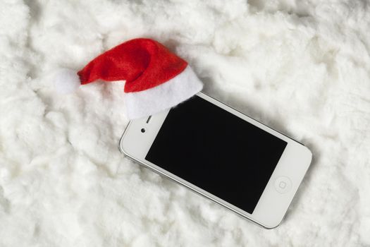 Cellphone with santa hat surrounded by white cotton
