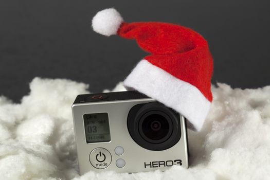 Camera with santa hat surrounded by white cotton