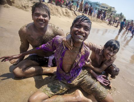 Indian men celebrating Holi on Juhu Beach in Mumbai.