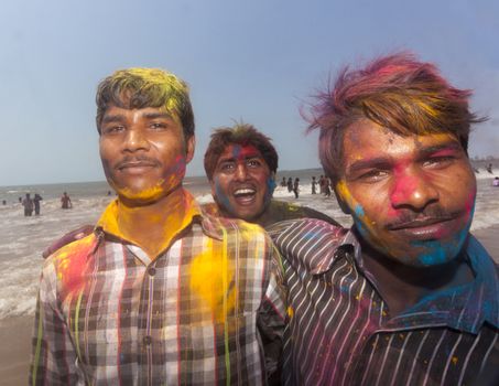 Indian men celebrating Holi on Juhu Beach in Mumbai.