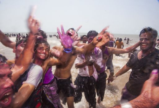 Young people celebrating Holi on Juhu Beach in Mumbai.
