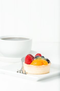 Colorful fresh fruit tart served with coffee.