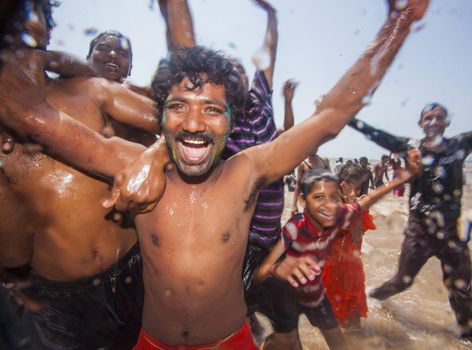 Indian men celebrating Holi on Juhu Beach in Mumbai.