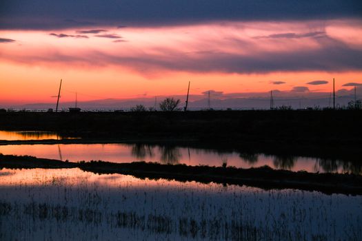 Sunset on saltpans with a church in the back (in Strunjan/Piran, Slovenia)