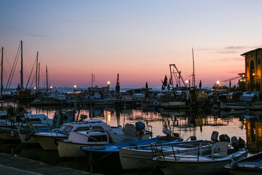 Marine at dusk with fishing boats and yachts.