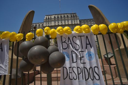 ARGENTINA, Buenos Aires: Hard hats rest on a fence in Buenos Aires, on February 1, 2016, in a show of support with 140 workers who were fired. The sign reads 'No More Layoffs'